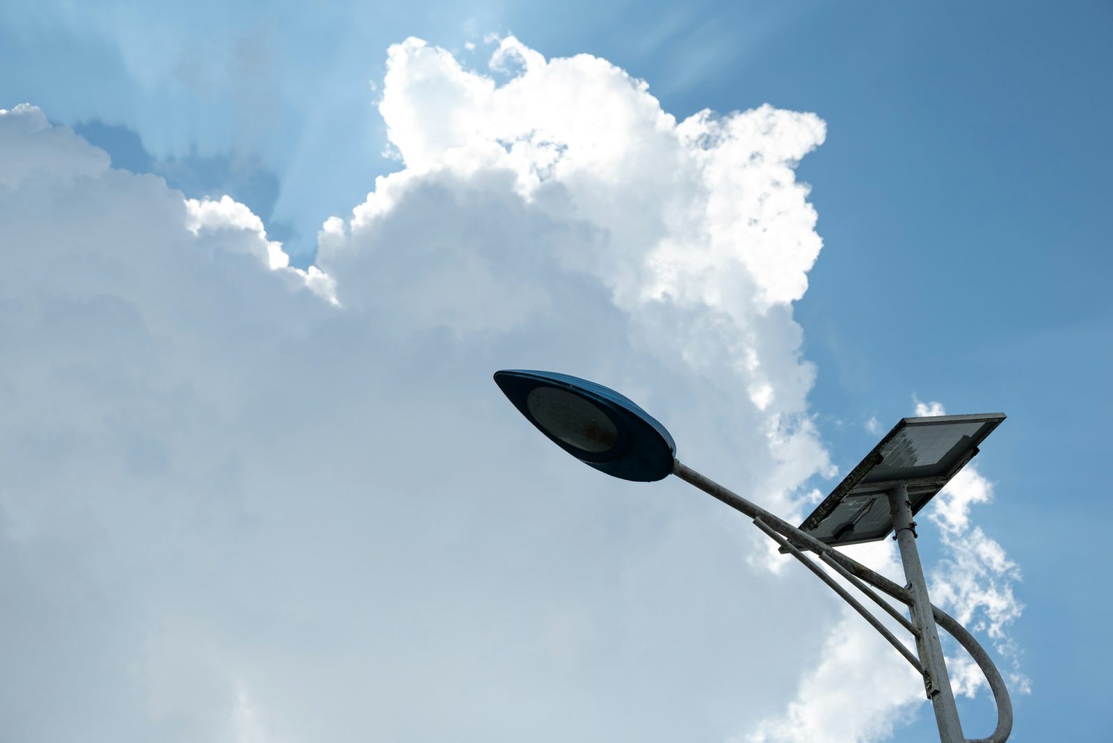 Poste de iluminação de LED com placa solar contra o céu com nuvens
