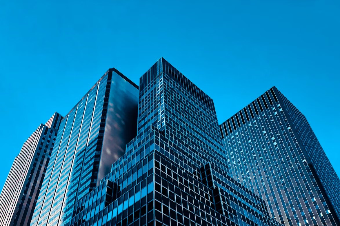 Prédios espelhados vistos de baixo contra o céu azul